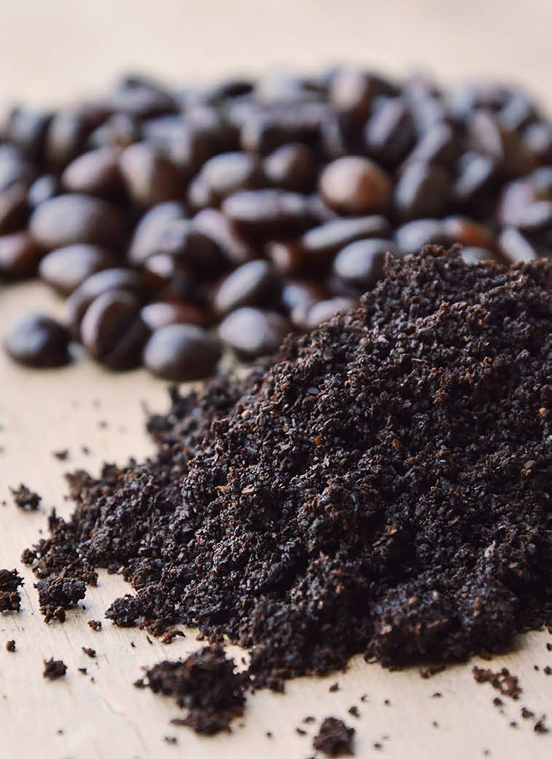 Coffee grounds with coffee beans in the backgrounds